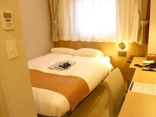 a hotel room with a bed with a window at Tokyo Inn in Tokyo