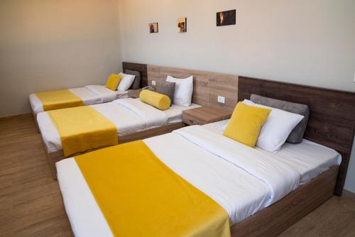 two beds in a room with yellow and white at Al Dora Resort All Inclusive Hotel in Hurghada