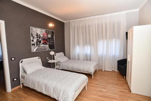 een slaapkamer met 2 bedden en een rode bus bij L'Agrifoglio Affittacamere in Gattinara