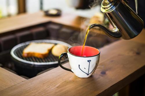 a coffee being poured into a cup on a table at ログコテージ茶臼の森 in Nasu