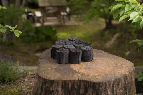 a group of blackoids sitting on top of a tree stump at ログコテージ茶臼の森 in Nasu