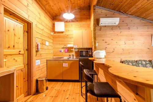 a kitchen with a counter in a wooden cabin at ログコテージ茶臼の森 in Nasu