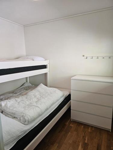 a white bedroom with a bunk bed and a dresser at Mountain view 2 in Håra