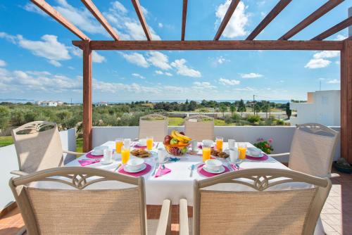 a table with food and orange juice on top of a balcony at Orianna Sea View Villa in Gennadi