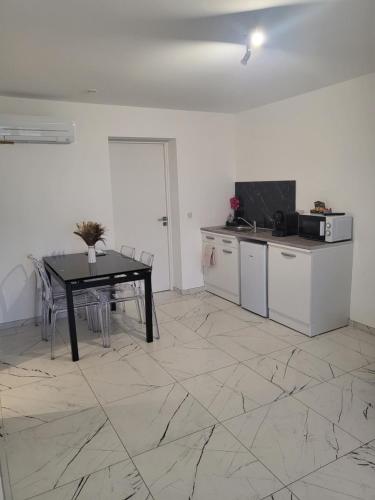 un salon avec une table et une cuisine dans l'établissement Solenzara T2 proximité plage, à Sari-Solenzara