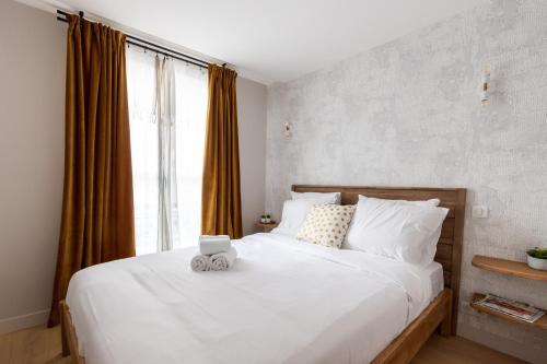 - une chambre dotée d'un lit blanc avec un ours en peluche dans l'établissement Relax in a Contemporary Designer Apartment, à Paris