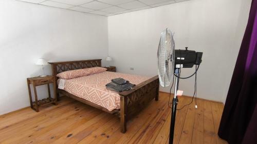a bedroom with a bed with a fan and a camera at Duplex con patio y cochera, con aire acondicionado y vajilla completa en el centro de Choele Choel in Choele Choel
