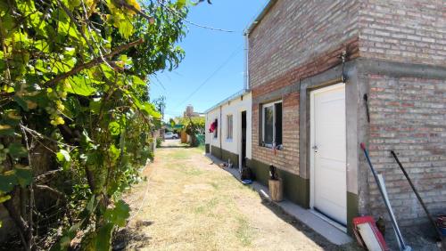 a side view of a brick building with a garage at Duplex con patio y cochera, con aire acondicionado y vajilla completa en el centro de Choele Choel in Choele Choel