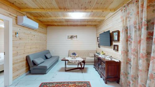 a living room with a couch and a table at בית הזורע של רשת לב הגולן - 4 צימרים מדהימים עם בריכה משותפת ליד הכנרת in Menaẖemya