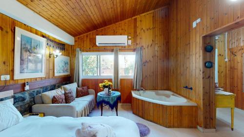 a bedroom with a bed and a bath tub at בית הזורע של רשת לב הגולן - 4 צימרים מדהימים עם בריכה משותפת ליד הכנרת in Menaẖemya