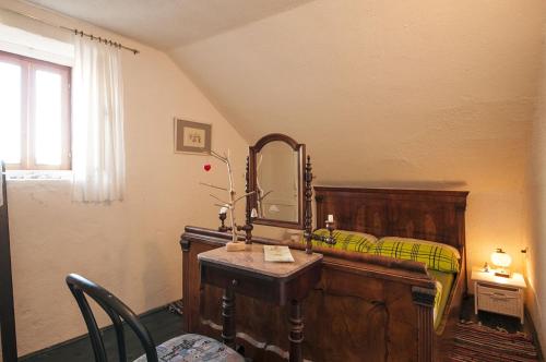 1 dormitorio con 1 cama y vestidor con espejo en Stone house Na Rudini en Zlarin