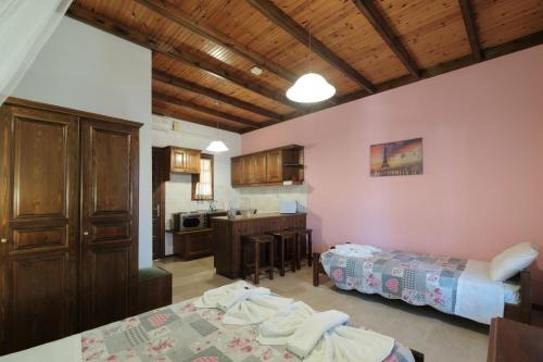 a living room with two beds and a kitchen at Nikos Pool Apartments - Upper Floor in Sidari
