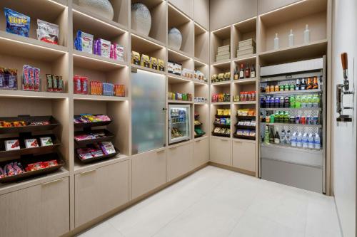 a supermarket aisle with shelves and a refrigerator at AC Hotel St Petersburg Downtown in St Petersburg