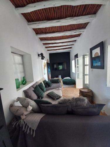 a room with a large bed with pillows on it at Les jardins de Silona, piscine chauffée in Essaouira