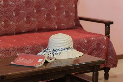 a white hat sitting on a table with a book at Nikos Pool Apartments - Upper Floor in Sidari