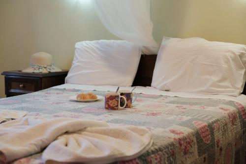 a bed with a blanket and a plate of food on it at Nikos Pool Apartments - Upper Floor in Sidari