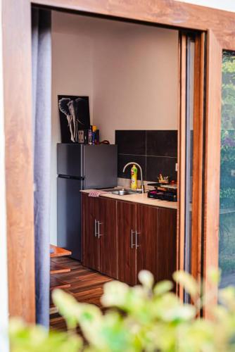 a kitchen with a black refrigerator and a sink at Secret Garden Villa in Kendwa