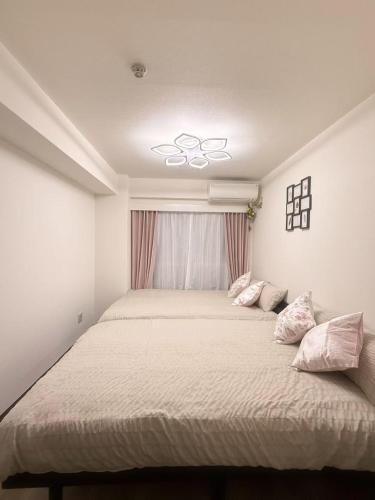 a bedroom with a large bed with pink pillows at Shinjuku Kabukicho 新宿最中心 東新宿5分 新宿9分 MAX4人 直達 渋谷原宿上野秋葉原 in Tokyo