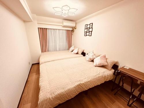 a bedroom with two beds and a window at Shinjuku Kabukicho 新宿最中心 東新宿5分 新宿9分 MAX4人 直達 渋谷原宿上野秋葉原 in Tokyo