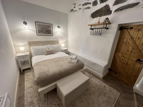 - une chambre avec un lit et une porte en bois dans l'établissement Stunning Cottage near Aber Falls, à Aber