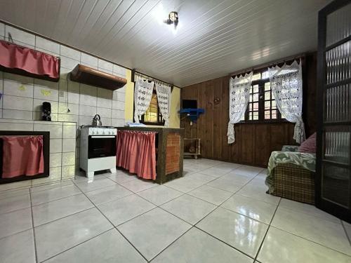 a room with a kitchen with a stove top oven at Pousada do Oasis in Morretes