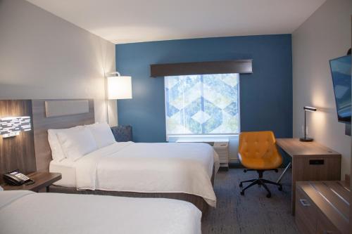 a hotel room with two beds and a desk and a window at Holiday Inn Express & Suites Overland Park by IHG in Overland Park