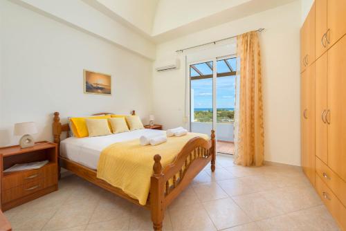 a bedroom with a bed and a large window at Orianna Sea View Villa in Gennadi