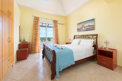 a bedroom with a bed and a large window at Orianna Sea View Villa in Gennadi