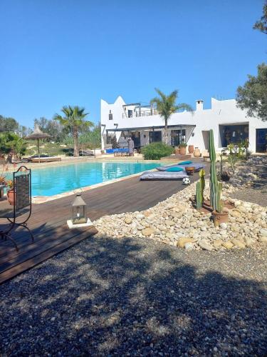 a view of a swimming pool and a house at Les jardins de Silona, piscine chauffée in Essaouira