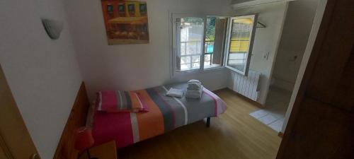 une petite chambre avec un lit et deux fenêtres dans l'établissement Residence PLEIN SUD, à Péré