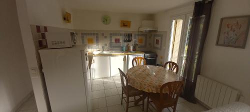une petite cuisine avec une table et un réfrigérateur dans l'établissement Residence PLEIN SUD, à Péré