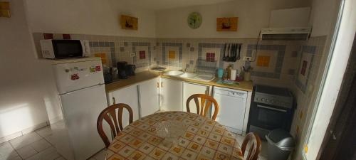 une petite cuisine avec une table et une table et des chaises dans l'établissement Residence PLEIN SUD, à Péré