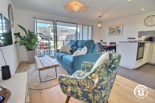 un salon avec un canapé bleu et une table dans l'établissement Thinic appartement VUE MER et SPA, à Saint-Pierre-Quiberon