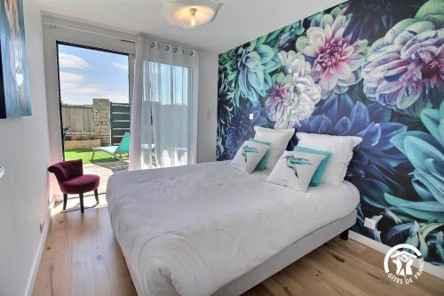 - une chambre avec une grande fresque murale représentant des fleurs dans l'établissement Thinic appartement VUE MER et SPA, à Saint-Pierre-Quiberon