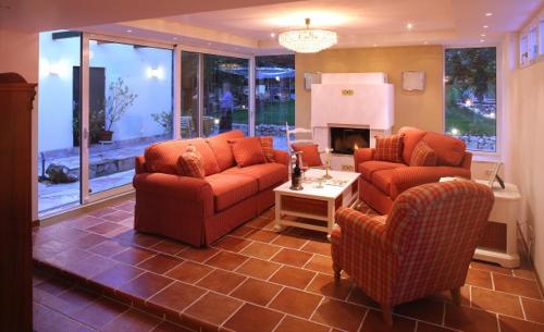 sala de estar con 2 sofás y chimenea en Romantic Cottage, en Pitten