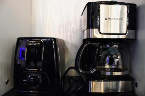 a coffee maker sitting next to a coffee machine at Caryolba hometel - Calapan in Calapan