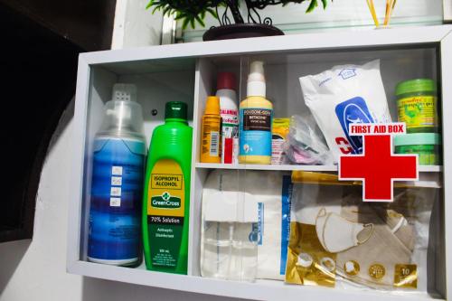 a refrigerator filled with lots of bottles and a red cross at Caryolba hometel - Calapan in Calapan