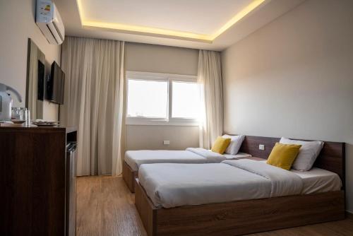 a hotel room with two beds and a window at Al Dora Resort All Inclusive Hotel in Hurghada