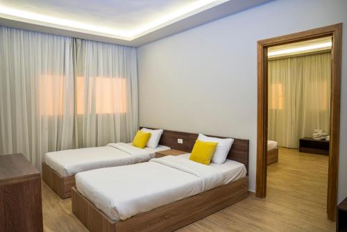a hotel room with two beds and a mirror at Al Dora Resort All Inclusive Hotel in Hurghada
