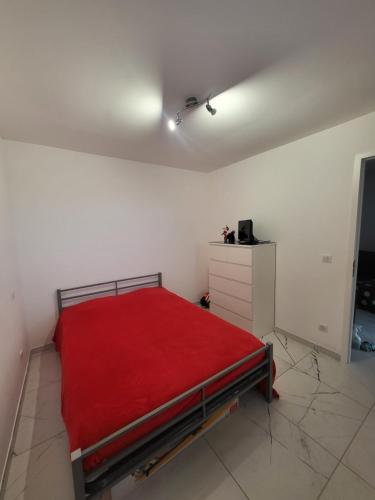 une chambre avec un lit avec une couverture rouge dans l'établissement Solenzara T2 proximité plage, à Sari-Solenzara