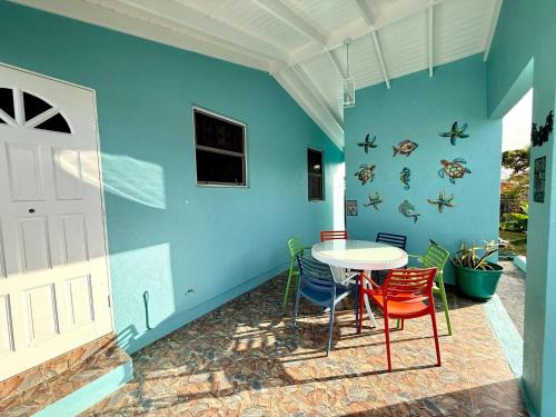 a table and chairs in a room with a blue wall at ZenBreak Steps to the Sea 2Bd in Saint Peter