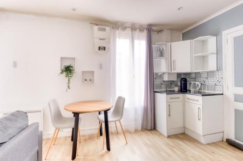 une petite cuisine avec une table et des chaises dans une pièce dans l'établissement Spacieux T2 proche la Défense, à Bezons