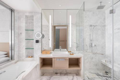 a bathroom with a tub and a sink and a shower at Renaissance Shanghai Caohejing Hotel in Shanghai