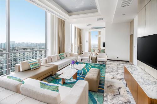 a living room with a couch and a tv at Renaissance Shanghai Caohejing Hotel in Shanghai