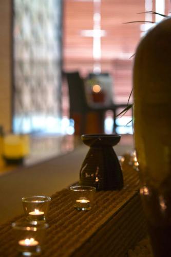 a table with two votive candles and a vase at Renaissance Shanghai Caohejing Hotel in Shanghai