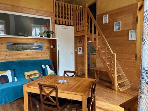 - un salon avec une table en bois et un escalier dans l'établissement Appartement, à Ax-les-Thermes