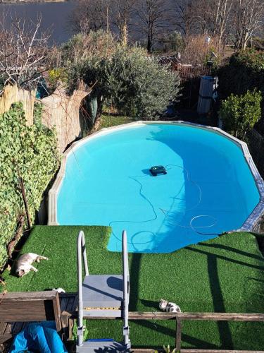 a blue swimming pool with two chairs in the grass at Le Rose Sul Lago in Pescate