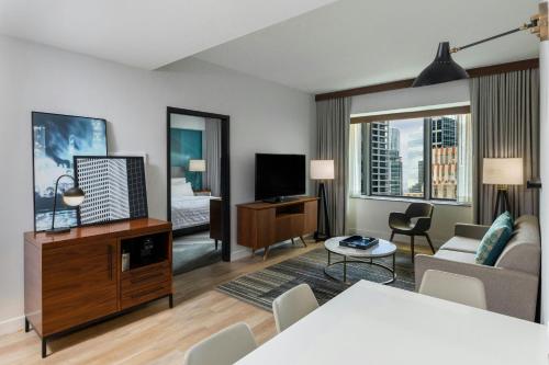 a living room with a couch and a tv at Le Meridien Houston Downtown in Houston
