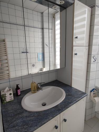 une salle de bain avec un lavabo et un miroir dans l'établissement Location Keransignour, à Concarneau