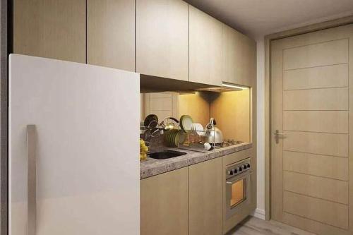 a kitchen with a stove and a white refrigerator at Gem Room for Rent in Cebu City